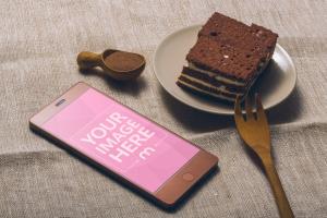 Android Smartphone and Piece of Cake on Desk Mockup Generator