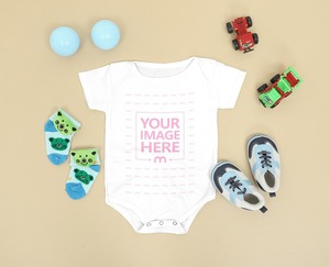 Baby Bodysuit Mockup Laid on the Floor Close by Baby Shoe and Socks