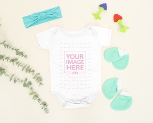 Baby Bodysuit Mockup Laid Over a Light Brown Background