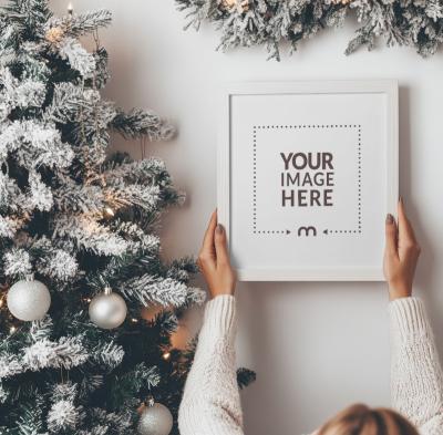 Christmas-Themed Empty Frame Mockup Held by Woman from Top View