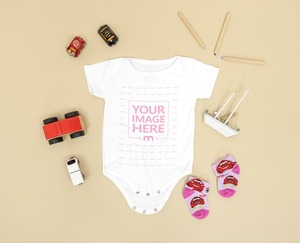 Flatlay Baby Onesie Mockup Flat Laid on a Brown Background