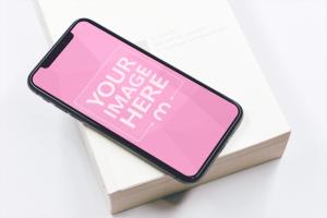 iPhone XS Lying on Book Mockup Generator