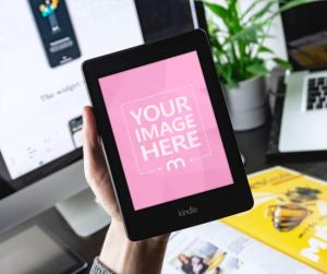 Kindle E-Book Reader in Hand on Office Background Mockup Generator