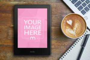 Kindle E-Reader on Desk Next to Laptop and Coffee Mockup Generator