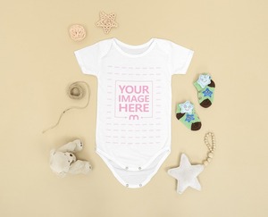 Mockup of a Baby Bodysuit Surrounded by Some Baby Accessories