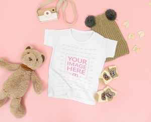 Mockup of a Baby Shirt Flat Laid Over Pink Background