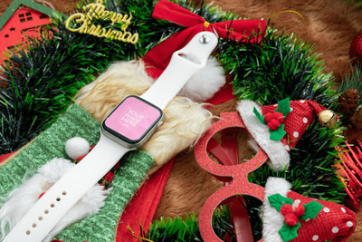 Mockup of a Smartwatch Above a Christmas Stock and Beside a Round Red Glasses