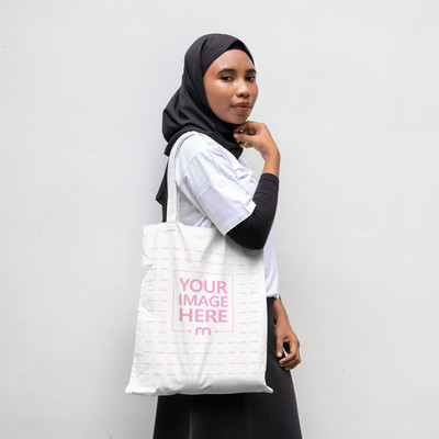 Mockup of a Tote Bag on the Side of a Posing Woman Close to a Wall