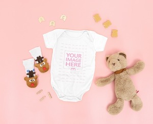 Mockup of Baby Bodysuit Laid on Pink Background