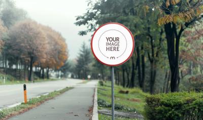 Round Street Sign Mockup on a Road Surrounded by Trees