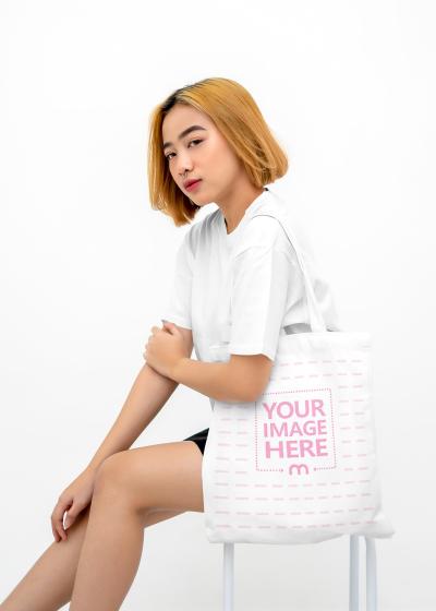 Shirt and Bag Mockup of a Posing Sitting Woman