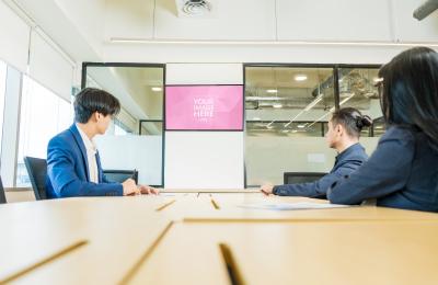 Three Person Meeting in Office with Presentation Screen on TV Mockup