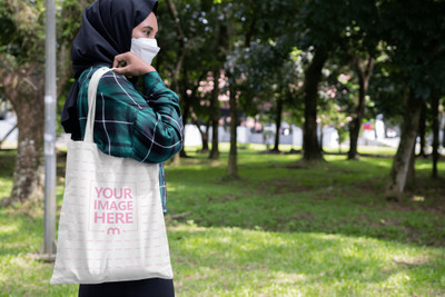 Tote Bag Mockup on the Side Shoulder of a Woman With Nature Background