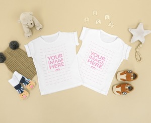 Two Flatlay Baby Shirt Mockup Placed on Top of a Brown Background