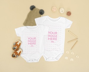 Two Size Baby Onesie Mockup Laid Over a Brown Background