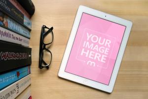 White iPad on Wood Table Next to to Books and Glasses Mockup