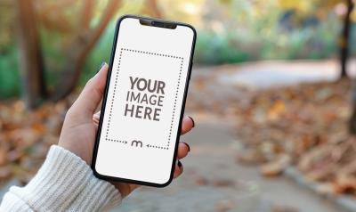 Woman Displaying Smartphone Mockup in a Beautiful Park